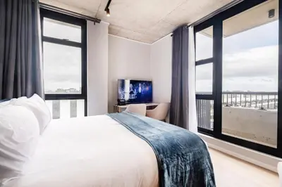 a bedroom with a bed and a large window at 404 Riverlands - Studio Apartment with Parking in Cape Town