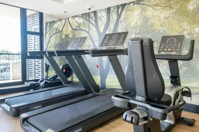 a gym with a treadmill in front of a window at 404 Riverlands - Studio Apartment with Parking in Cape Town