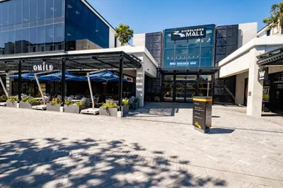 a shopping center with blue umbrellas in front of a building at 404 Riverlands - Studio Apartment with Parking in Cape Town