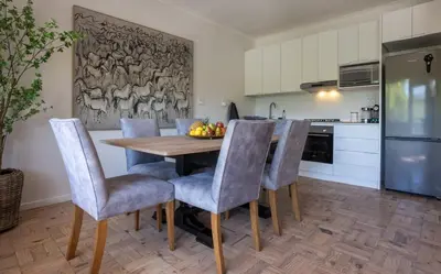 a kitchen with a wooden table and chairs at The Ya Ya Apartment in Stellenbosch
