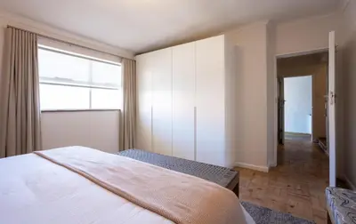 a bedroom with a bed and a large window at The Ya Ya Apartment in Stellenbosch