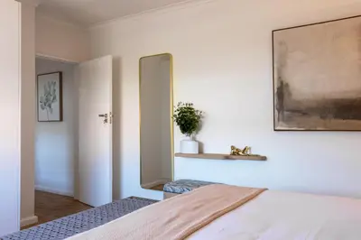 a bedroom with a mirror on the wall and a bed at The Ya Ya Apartment in Stellenbosch