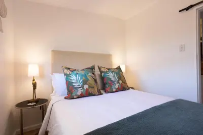 a bedroom with a white bed with two pillows at The Ya Ya Apartment in Stellenbosch