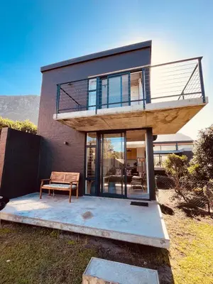 a house with a balcony on top of it at The Glass House Loft in Bettyʼs Bay