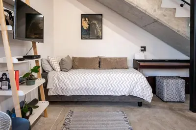 a bedroom with a bed and a piano at The Glass House Loft in Bettyʼs Bay