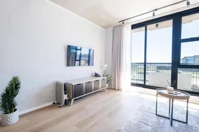 a living room with white walls and a large window at 207 Riverlands - 1 Bedroom Apartment with Parking in Cape Town