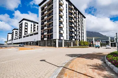 an empty street in front of a large building at 207 Riverlands - 1 Bedroom Apartment with Parking in Cape Town