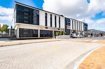 an empty street in front of a large building at 504 Riverlands - Lux 2 Bedroom Apartment with Parking in Cape Town