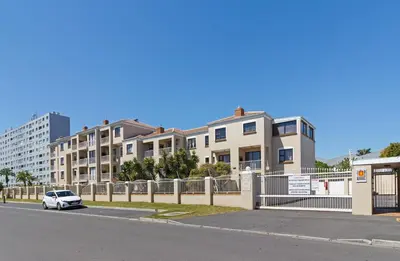 a white car parked in front of some buildings at San Norina Gardens 5 in Cape Town
