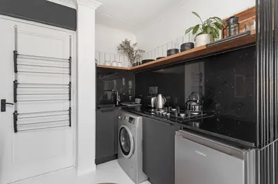 a kitchen with a stove and a washing machine at San Norina Gardens 5 in Cape Town