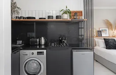 a kitchen with a stove and a washing machine at San Norina Gardens 5 in Cape Town
