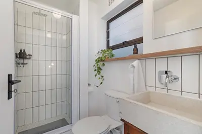 a bathroom with a shower and a toilet and a sink at San Norina Gardens 5 in Cape Town