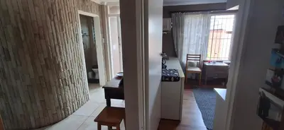a view of a kitchen and a dining room with a table at Pug's Room in Welgemoed