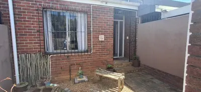 a brick wall with a bench and a window at Pug's Room in Welgemoed