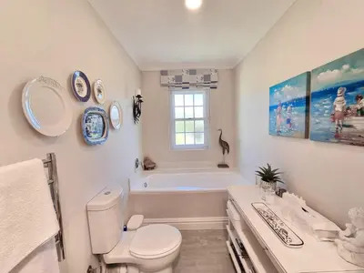 a bathroom with a toilet and a tub and a sink at Moonlight in Hermanus