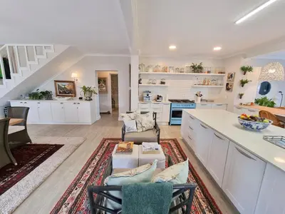 a large kitchen with white cabinets and a counter at Moonlight in Hermanus