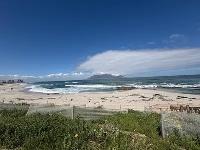 a beach with a view of the ocean and mountains at Serenity suite 6 minutes away from the beach in Cape Town