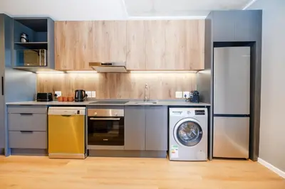 a kitchen with a washing machine and a washer at 511 Riverlands - Lux 2 Bedroom Apartment with Parking in Cape Town