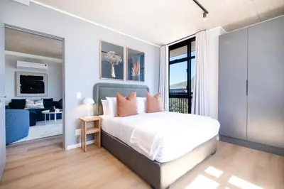 a bedroom with a bed and a living room at 511 Riverlands - Lux 2 Bedroom Apartment with Parking in Cape Town