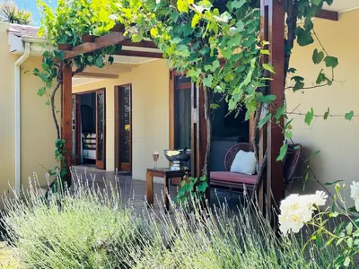 a patio with a table and chairs on a house at Family home with table mountain view and pool in Stellenbosch