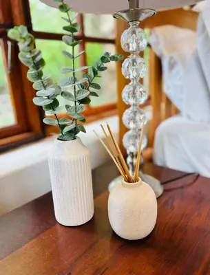 two white vases sitting on a wooden table at Family home with table mountain view and pool in Stellenbosch