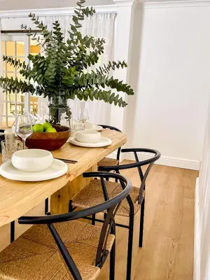a dining room table with chairs and a vase with a plant at Mountain views oasis in Franschhoek