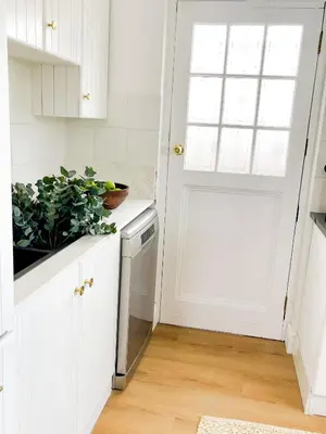 a kitchen with white cabinets and a white door at Mountain views oasis in Franschhoek