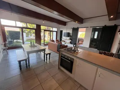 a kitchen and living room with a table and a dining room at Durr's Nest - Central Paarl Mountain Retreat in Paarl