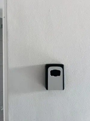 a black and white switch on a white wall at Entire Modern, Secure & Central Flat in Milnerton in Cape Town
