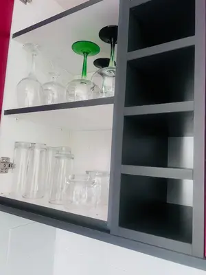 a shelf with glass jars and vases on it at Entire Modern, Secure & Central Flat in Milnerton in Cape Town