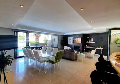 a living room with a table and chairs at Cape Town Sunset Beach Luxury Beachfront Villa in Cape Town