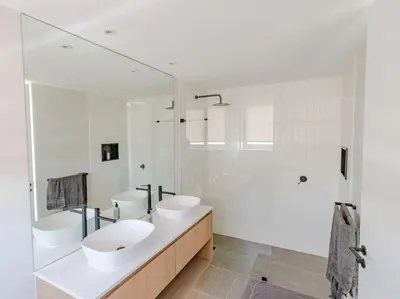 a white bathroom with two sinks and a shower at Ocean 9 Beachfront Residence in Cape Town