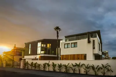 a house with a palm tree in front of it at Ocean 9 Beachfront Residence in Cape Town