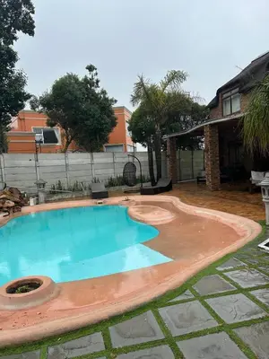a swimming pool in a yard with a house at Daisy Accommodation & Spa in Cape Town