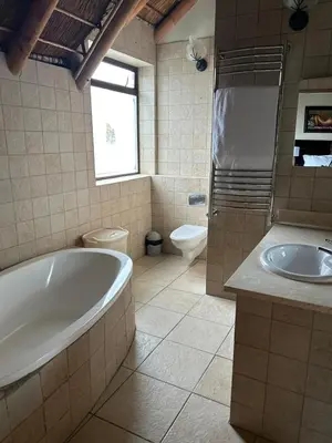 a bathroom with a tub and a toilet and a sink at Daisy Accommodation & Spa in Cape Town