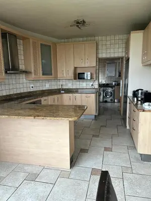 a kitchen with wooden cabinets and a large counter top at Daisy Accommodation & Spa in Cape Town