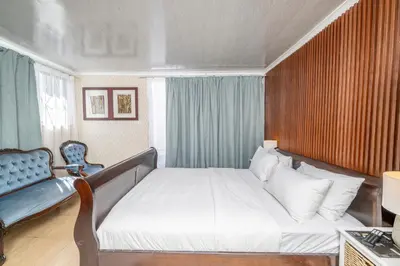 a bedroom with a bed and a blue chair at Self Contained 2 bed Room Condo in Parow