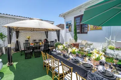 a table with chairs and an umbrella on a patio at Self Contained 2 bed Room Condo in Parow