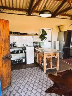 a kitchen with a table and a refrigerator at The Old Dairy at Allemanskloof in Paarl