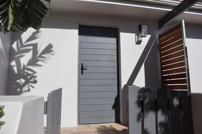 a house with a garage door and two windows at Sunset sea views - 4 bedroom home in Hermanus