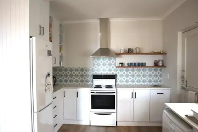 a kitchen with white cabinets and a stove top oven at Sunset sea views - 4 bedroom home in Hermanus
