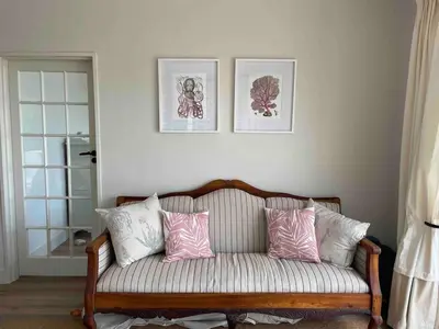 a couch with pink and white pillows in a room at Sunset sea views - 4 bedroom home in Hermanus