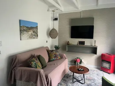 a living room with a couch and a flat screen tv at carol close1 small apartment in Eversdal