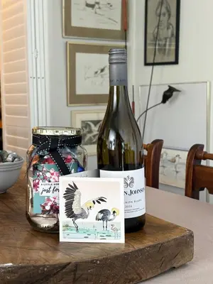 a bottle of wine sitting on a table next to a jar at The Modest Mansion in Cape Town