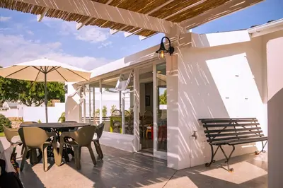 a patio with a table and chairs and an umbrella at Cali House, Kwaaiwater Getaway in Hermanus