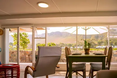 a dining room with a table and chairs and a window at Cali House, Kwaaiwater Getaway in Hermanus