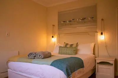 a bedroom with a bed with towels on it at Cali House, Kwaaiwater Getaway in Hermanus
