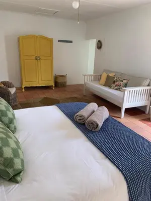 a bedroom with a large bed with towels on it at Cali House, Kwaaiwater Getaway in Hermanus
