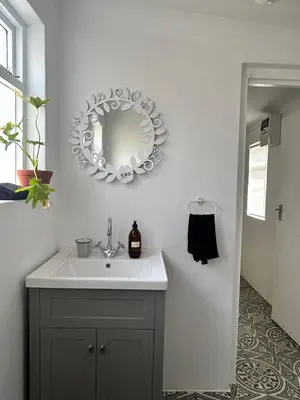 a bathroom with a sink and a mirror on the wall at Cali House, Kwaaiwater Getaway in Hermanus