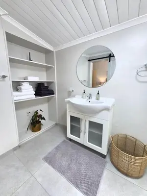 a white bathroom with a sink and a mirror at SleepINN at Dumont in Paarl